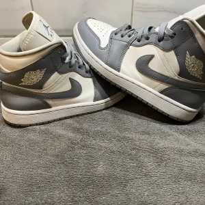 Nike Air Jordans i grått och vitt - Snygga Nike Air Jordans i en stilren kombination av grått och vitt. Skorna har klassisk snörning och den ikoniska Air Jordan-loggan på sidan. Perfekta för dig som vill ha en tidlös och sportig look. Pris kan diskutera 