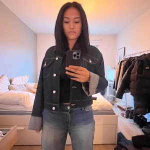 Mörkblå jeansjacka  - Säljer en snygg mörk blå jeansjacka. Jackan har en klassisk design med knappar framtill och två bröstfickor med lock. Den är långärmad och har en normal passform. Perfekt för en cool och avslappnad stil.