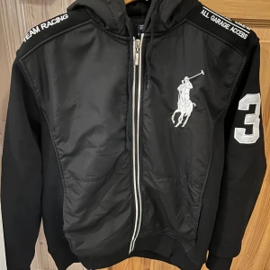 Ralph Lauren Polo racing jacka - Säljer en Ralph Lauren Polo jacka i modellen racing. Den är vadderad innuti och har huva. Jackan finns inte längre för nyförsäljning och köptes för 5400. Den är använd väldigt få gånger och är i felfritt skick. Storleken är S men passar även M. Pris går att diskutera vid snabb och seriös affär