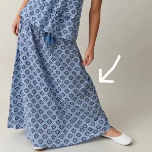 Blå mönstrad långkjol - Säljer en blå långkjol med ett snyggt geometriskt mönster💙Kjolen har en elastisk midja och dekorativa tofsar framtill. Perfekt för  sommaren! Passar mig som har xs/s i vanliga fall!💕