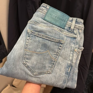 Jacob Cohën jeans  - Snygga blå jeans från Jacob Cohën med en klassisk femficksdesign och knappgylf. Jeansen har en ljus tvätt och är tillverkade i Italien. Perfekta för en stilren look.