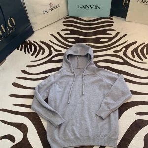 Grå hoodie med huva och snörning - Säljer en stilren grå hoodie med huva och snörning. Tröjan har långärmade raglanärmar och ribbade muddar vid ärmslut och nederkant. Perfekt för chill dagar och enkel att matcha med jeans eller joggers.