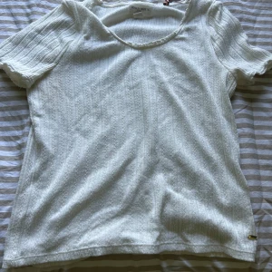 Vit ribbad tröja - En vit ribbad tröja i fint mönster och med en gulddetalj på sidan, har använts ca 2-3 gånger och är i storlek L. Pris kan diskuteras🫶🏻