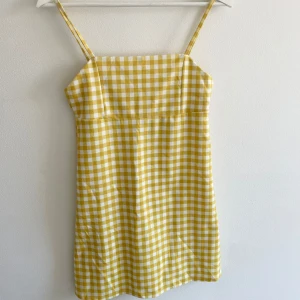 Gul och vit rutig klänning Pull&Bear - Superfin kort klänning från Pull&Bear i gul och vit rutig. Klänningen har smala axelband. Perfekt för dig som gillar färg och mönster! Storlek S.