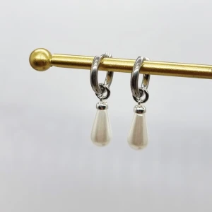 Silverörhängen med vita pärldroppar - Snygga örhängen i silverfärgad metall med hängande droppformade vita pärlor. Perfekt för dig som gillar stilrena och eleganta smycken med en modern twist. Passar till både jeans och klänning och ger en fräsch touch till din look.