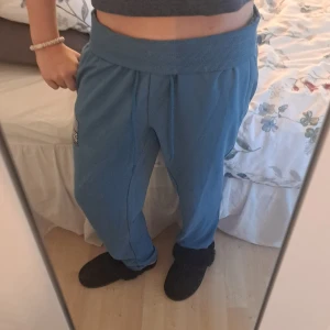 Blå mjukisbyxor från Max, strl S - Säljer ett par blå mjukisbyxor från Max i storlek small. Byxorna har bred ribbad midja med snörning, raka ben och en patch med texten 'Super Sport' på ena benet. Sköna och avslappnade, perfekta för chill dagar.
