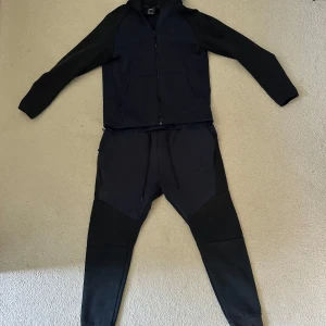 Nike tech fleece tracksuit - Nike tech fleece gammal modell men knappast använd. Har en liten rivskada på byxan som man ser på bilden. Annars är skicken helt ny. 