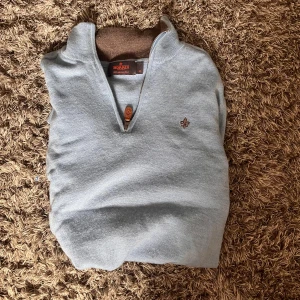 Ljusblå stickad tröja från Morris🤩 - Snygg ljusblå stickad tröja från Morris med half zip och brunt läderdetalj på dragkedjan. Tröjan passar storlek Xs då den har krympt i tvätten/ hör av dig vid frågor🤩🙌