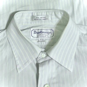 Burberry Skjorta - Cool vintage Burberry skjorta. Företaget bytte namn under 90 talet från Burberrys of London till nuvarande Burberry. Skjortan är lite see through och väldigt tunn. Skicket skjortan finner sig i är bra.