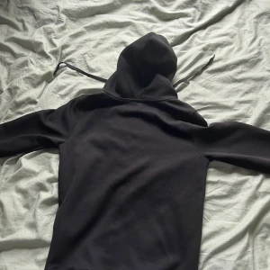 Svart hoodie från Polo Ralph Lauren - Svart hoodie från Polo Ralph Lauren i custom fit med vit broderad logga på bröstet. Tröjan har huva med snörning, dragkedja framtill och två fickor. Materialet är mjuk bomull och polyester, perfekt för chill dagar. Klassisk och stilren design som funkar till allt. Storlek M men lite liten u storleken passar bättre till S.