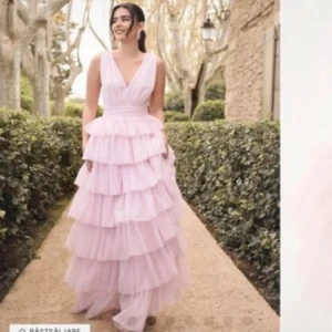 Ljusrosa långklänning med volanger - Säljer en drömmig ljusrosa långklänning med flera lager volanger och v-ringad front. Klänningen har breda axelband och en öppen rygg, använd vid ett tillfälle som var min studentlunch som varade i 2 timmar. Topp skick. Köpt för 1799 kr. Buda gärna💓💓POSTAR ENDAST MED POSTNORD, AVBRYTER KÖPET ANNARS