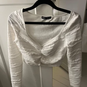 Vit croppad topp från SHEIN - Säljer en vit croppad topp från SHEIN med lång ärm och v-ringad hals. Använd en gång 