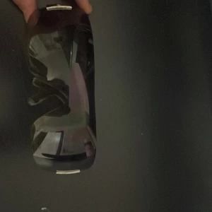 Svarta solglasögon  - Säljer ett par chunky svarta  solglasögon med breda bågar och stora bruna glas. På sidorna sitter silverfärgade metallplattor. Glasögonen har en futuristisk vibe och är tillverkade i plast med metall-detaljer.