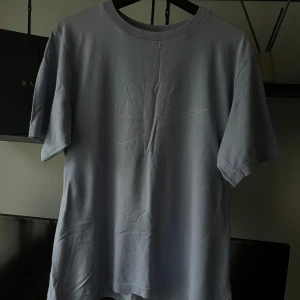 Ljusblå Nike t-shirt  - Snygg ljusblå t-shirt från Nike i storlek L (passar mer som storlek M). Klassisk rund hals och korta ärmar. Diskret Nike-logga tryckt på bröstet i samma färg som tröjan. Mjuk och skön bomull som passar perfekt till jeans eller shorts. 
