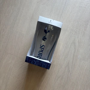 Glas - Det här är ett pintglas med Tottenham Hotspur FC:s logga och texten 'SPURS'. Perfekt för dig som är fotbollsfan och vill visa ditt stöd för laget när du tar en dryck med vänner. Glaset levereras i originalförpackning och är en snygg detalj för alla Spurs-supportrar.