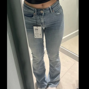 Ljusblå bootcut jeans  - Snygga ljusblå jeans med bootcut. Jeansen har klassisk femficksdesign, dragkedja och knapp framtill. Materialet är mjukt denim som sitter skönt och formar sig efter kroppen. Perfekta för en trendig och avslappnad look.