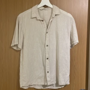 Beige linneskjorta från H&M -  beige skjorta från H&M.