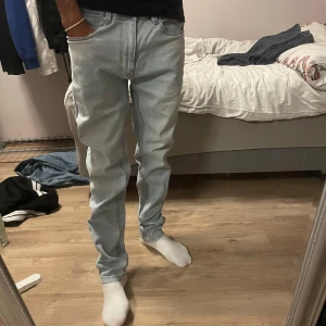 Ljusblå jeans från Zara, strl 32 - Säljer ett par ljusblå jeans från Zara i storlek 32. Jeansen har klassisk femficksdesign, raka ben och normal passform. Tillverkade i mjukt denimtyg som är skönt att bära. Perfekta för dig som gillar en clean och enkel look.