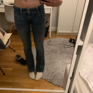 Blå bootcut jeans med låg midja - Säljer ett par klassiska blå jeans med bootcut och låg midja. Storlek 170, passar 34 eller XS. 