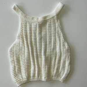 Vit stickad linnetopp från Giorgia - Supersnygg vit stickad linnetopp från Giorgia med breda axelband och ribbade kanter. Toppen är genomskinlig så den passar perfekt över bikini till stranden. Passar grymt till både jeans och kjol. Toppen är kort och slutar ovanför naveln på en som är 167 cm. Skulle säga att toppen är mer storlek S än M. Plagget är inte användt och har lappen kvar. 