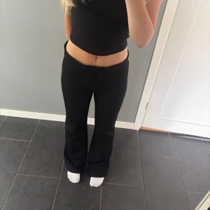 Svarta kostymbyxor från Nelly - Säljer ett par svarta kostymbyxor från Nelly i storlek S. Byxorna har låg midja och är bootcut. Passar även storlek M. 