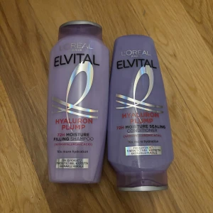 L'Oréal Elvital Hyaluron Plump duo - Lila flaskor med L'Oréal Elvital Hyaluron Plump 72H Moisture Filling Shampoo (250 ml) och Moisture Sealing Conditioner (200 ml). Båda innehåller hyaluronsyra för extra återfuktning och är perfekta för torrt hår. Flaskorna är tillverkade av återvunnen plast. HELT NYA
