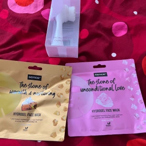 Sence hydrogel ansiktsmasker & borste - Två hydrogel ansiktsmasker från Sence: en med kamomillolja i guldgul för lyster och en rosa med hyaluronsyra för återfuktning. Båda är veganska. Medföljer gör en vit ansiktsborste med dubbla borsthuvuden för rengöring.