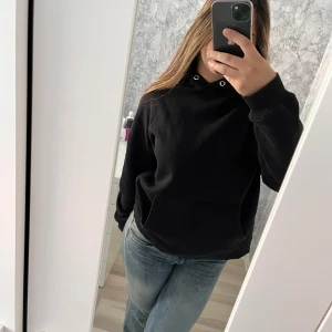 Svart hoodie från Nelly - Svart hoodie från NLY Trend i storlek S. Klassisk modell med huva, snörning och stor magficka. Mjuk insida och ribbade muddar vid ärmslut och nederkant. Perfekt för chill dagar och enkel att matcha med jeans eller joggers. Vid frågor hör av dig!
