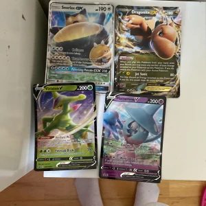 Pokémonkort: Snorlax GX, Dragonite EX, Virizion V, Hatterene V - Samling av fyra coola Pokémonkort med Snorlax GX, Dragonite EX, Virizion V och Hatterene V. Perfekt för dig som gillar att samla, byta eller spela Pokémon TCG. Korten har färgstarka illustrationer och är populära bland unga samlare.