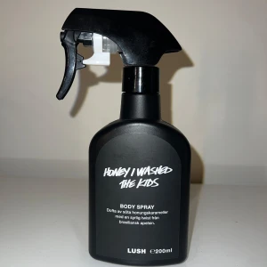 Lush Honey I Washed The Kids Body Spray - Body spray från Lush i svart plastflaska med spraymunstycke. Doftar söta honungskarameller med en syrlig twist av brasiliansk apelsin. Flaskan rymmer 200 ml och har en modern, stilren design. Endast test sprayat 