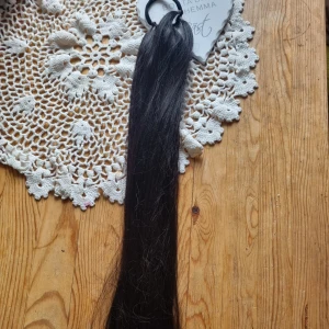 Svart hårförlängning clip-on - Lång och rak svart hårförlängning med clip-on fäste. Perfekt för att ge extra längd och volym till din frisyr. Enkel att sätta i och ta ur, passar till både vardagliga och mer stylade looks.