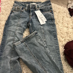 Lågmidjade Bootcut jeans  - Bootcut jeans från Gina Tricot i ljusblå tvätt med snygga broderade bakfickor. Klassisk femficksmodell, normal midja och coola kontrastsömmar. Perfekta för dig som gillar en avslappnad men trendig look.