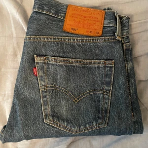 Levi's 501 blå jeans  - Hej! Säljer ett par Levis jeans då jag inte använder de längre. Har endast använt dessa ett fåtal gånger och de har inga synliga defekter. Köpta på Åhléns för 1100 kr. Pris kan diskuteras, hör av er vid intresse! 