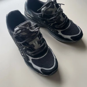 Svarta Asics Gel Nyc  - Säljer ett par helt oanvända Asics gel nyc. Svarta och i storlek 44. Skriv vid frågor. Box och kvitto följer inte med. Bara skorna. 
