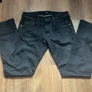Svarta Replay Anbass  - Svarta Replay Anbass Hyperflex jeans med klassisk femficksdesign och snygga svarta sömmar. Jeansen har stretchigt material för extra komfort och en slim passform som sitter snyggt. Perfekta för dig som gillar stilrena och bekväma jeans. Priset kan diskuteras vid snabb Affär 