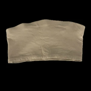 Beige tubtopp - Enkel och stilren beige tubtopp i mjuk bomullsmix. Toppen är ärmlös och axelbandslös, perfekt att styla med höga jeans eller kjol. Snygg basic som funkar till många olika looks. Den är stretchig. Har aldrig använt.