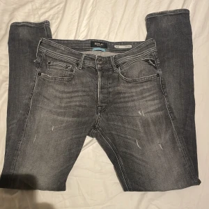 Replay Willbi grå slim jeans - Snygga grå jeans från Replay, modell Willbi Regular Slim Fit. Jeansen har en tvättad look med diskreta slitningar och klassiska fem fickor. De är tillverkade i stretchigt jeanstyg och har svarta detaljer samt Replay-logga på bakfickan.                                     .   Helt oanvända och sitter riktigt bra!🌟🤩