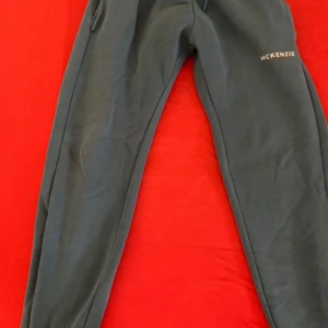 Ljusblå mjukisbyxor från McKenzie - Snygga ljusblå mjukisbyxor från McKenzie med logga på vänster lår. Byxorna har elastisk midja med snörning och är gjorda i mjukt bomullsmaterial. Perfekta för chill eller träning, med normal passform och praktiska sidofickor.