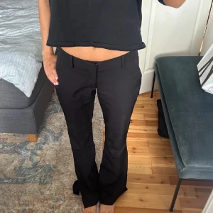Svarta bootcut kostymbyxor med slits - Snygga svarta kostymbyxor med bootcut passform och slits vid bensluten. Jag säljer dem på grund av att dom inte passar, köpte dom här på Plick men de passar inte.