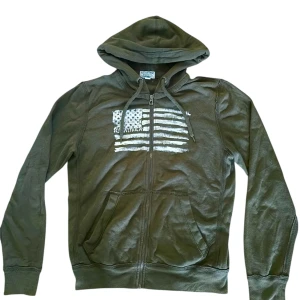 Ralph Lauren ZipUp - Säljer nu denna tvär feta ZipUp från Ralph lauren! Den är riktigt unik och svår att få tag på! Den är mörk/oliv grön med en snygg detalj på framsidan! Tröjan är i storlek S! Priset är ej hugget i sten!