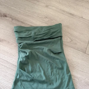 Grön bandeau topp från Zara - Banddeu topp i jätte fin grön färg. Tight passform med mjukt bomullsmaterial. Den ser lite skrynklig ut på bilden men sitter jätte fint på. Använt 1-2 gånger. 
