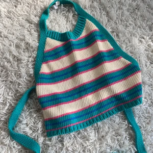 Stickad backless top - Superfin stickad halterneck topp från Zara med breda turkosa, rosa, blåa och cremefärgade ränder. Toppen har knytband runt ryggen för en snygg passform. Perfekt för sommarens alla tillfällen och ger en färgglad retrovibe.
