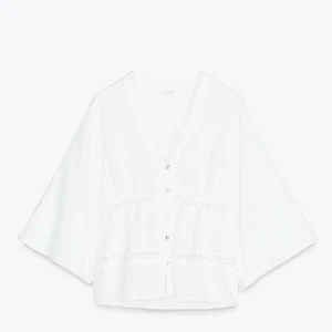 Vit blus med v-ringning från Zara - Superfin vit blus med v-ringning. Blusen har spetsdetaljer, perfekt att styla med jeans eller kjol för en fräsch look.💗💗