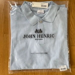 Oanvänd ljusblå pikétröja från John Henric - Helt ny och oanvänd. Bomulls pike från John Henric i storlek S. Piken är väldigt lik Ralph laurens. Nypris är 599kr. Hör av dig vid frågor! 