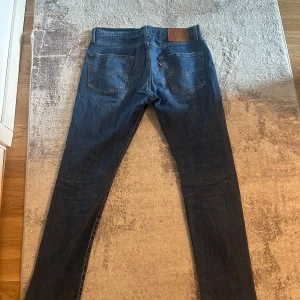 Levi's 511 mörkblå jeans - Säljer ett par klassiska Levi's 511 jeans i mörkblå tvätt. Modellen har raka ben, fem fickor och normal passform. Ikonisk läderpatch bak i midjan och den röda Levi's-taggen på bakfickan. Perfekta till sneakers eller boots. Priset går att förhandla!