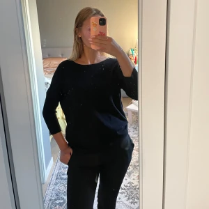 Svart långärmad tröja i bomull - Enkel och stilren svart långärmad tröja med rund halsringning. Tröjan har en avslappnad passform, perfekt för en clean och klassisk look. Passar till allt och är lätt att matcha med andra plagg.