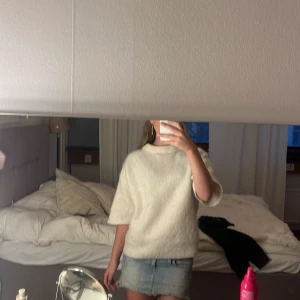 Vit stickad tröja med kort ärm - Supermysig vit stickad tröja med korta ärmar och rund hals. Tröjan har en relaxed fit och ribbade detaljer vid ärmslut, halsringning och nederkant. Från lindex.