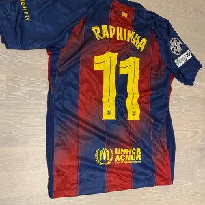 Barcelona Raphinha 25/26 T-shirt  - •Säljer en jätte fin 25-26 svart Barcelona T-shirt med CL patches och raphina på ryggen.  •Den är inte använd bara testad, jätte bra skick och inga fläckar eller hål.  •Och det är storlek M och måtten finns på dem sista bilderna •Priset kan diskuteras och skickar inom 24 Tim 💨😊
