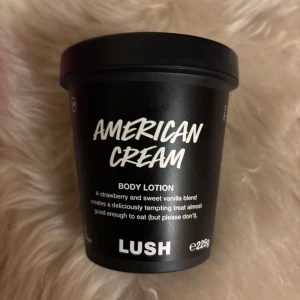 Limited Edition Lush Body Lotion - American Cream body lotion från Lush med doft av jordgubb och vanilj. Kommer i en svart plastburk på 225g. Innehåller mandelolja, kakaosmör, jojobaolja och eteriska oljor. Ger huden glow och en söt, nostalgisk doft. Cirka 75-80% kvar 