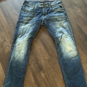 Replay Hyperflex Anbass jeans blå - Säljer ett par Replay Hyperflex Anbass jeans i blå tvätt med snygga slitningar och klassiska femficksdetaljer. Jeansen har smal passform och stretchigt material som gör dem riktigt bekväma. Perfekta för dig som gillar en modern och avslappnad stil. Pris kan diskuteras